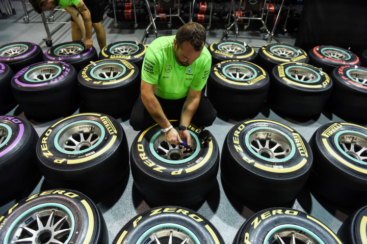 Seorang mekanik menyiapkan ban yang akan dipakai para pembalap berlatih dan berlaga. AFP PHOTO / Anthony WALLACE