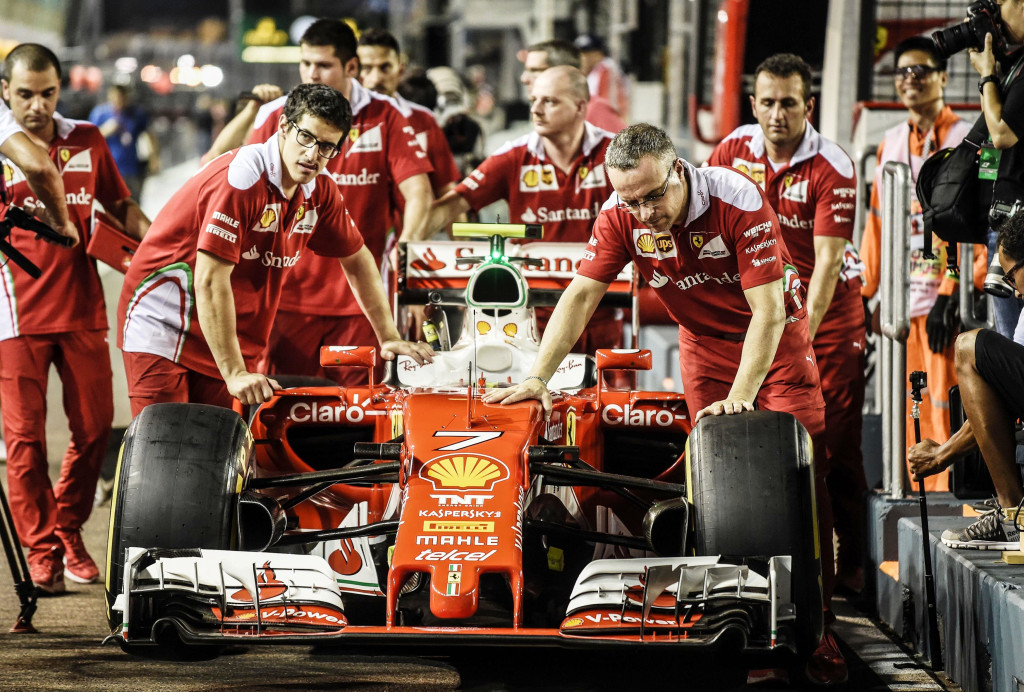 Tim mekanik Scuderia Ferrari mendorong mobil Kimi Raikkonen menuju pit lane Singapore Grand Prix in Singapore. AFP PHOTO / MOHD RASFAN