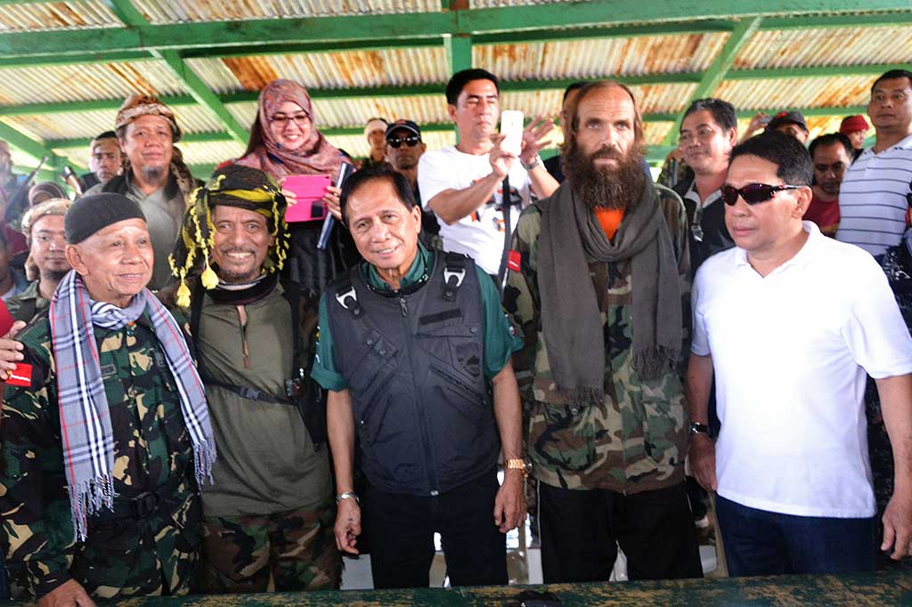 Penasihat perdamaian Filipina Jesus Dureza (ketiga kiri), bersama Pimpinan MNLF Nur Misuari (kedua kiri) WN Norwegia yang dibebaskan Kjartan Sekkingstad (kedua kanan) dan mantan Gubernur Sulu Sakur Tan (kanan) berpose bersama selama acara pembebasan.