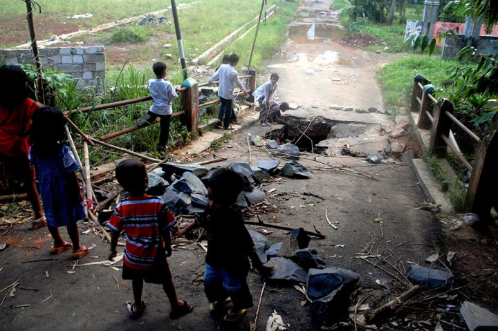 Anak-anak melihat jembatan yang ambles di Jalan Pitara, Pancoran Mas, Depok, Jawa Barat.