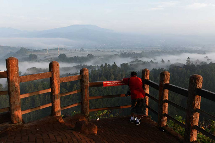 Seorang wisatawan mengabadikan indahnya pemandangan alam di Tebing Keraton, Kabupaten Bandung, Senin (19/9/2016).