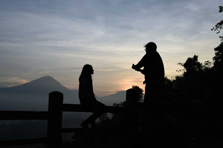 Wisatawan mengabadikan gambar rekannya saat matahari terbit di Tebing Keraton.
