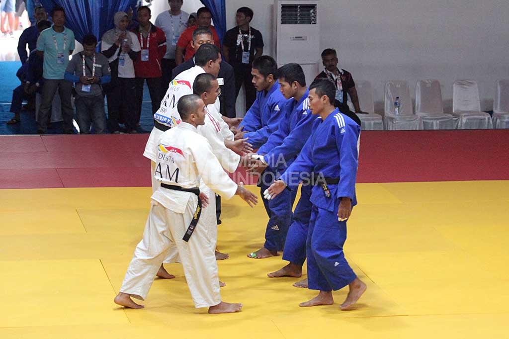 Kontingen judo DKI Jakarta nomor beregu putra PON XIX (pakaian putih), bersalaman dengan kontingen Banten, sebelum meninggalkan arena bertanding.