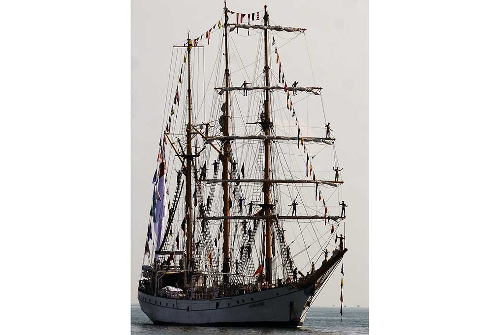 Kadet KRI Dewaruci melambaikan tangan saat akan sandar di Dermaga Layang Lantamal VI, Makassar.