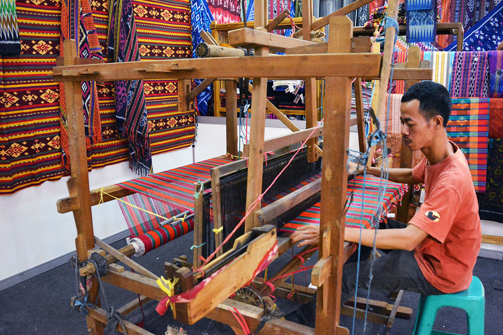 Seorang penjaga stan mempraktikkan cara menenun kain troso dengan alat tenun bukan mesin (ATBM), pada pameran produk UMKM 'Jepara Expo 2016' di Semarang.