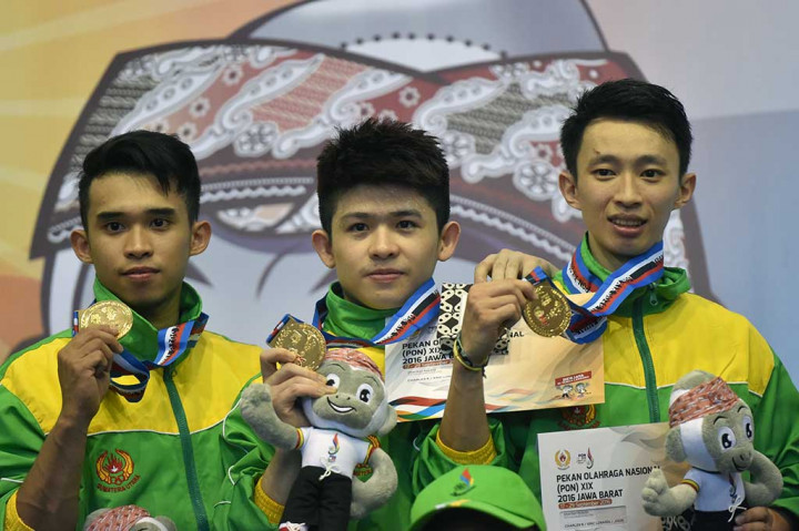 Atlet Wushu Sumut Jodis (kiri) bersama rekannya Eric Losardi (tengah) dan Charles Sutanto memperlihatkan medali emas nomor Duilian Putra PON XIX.