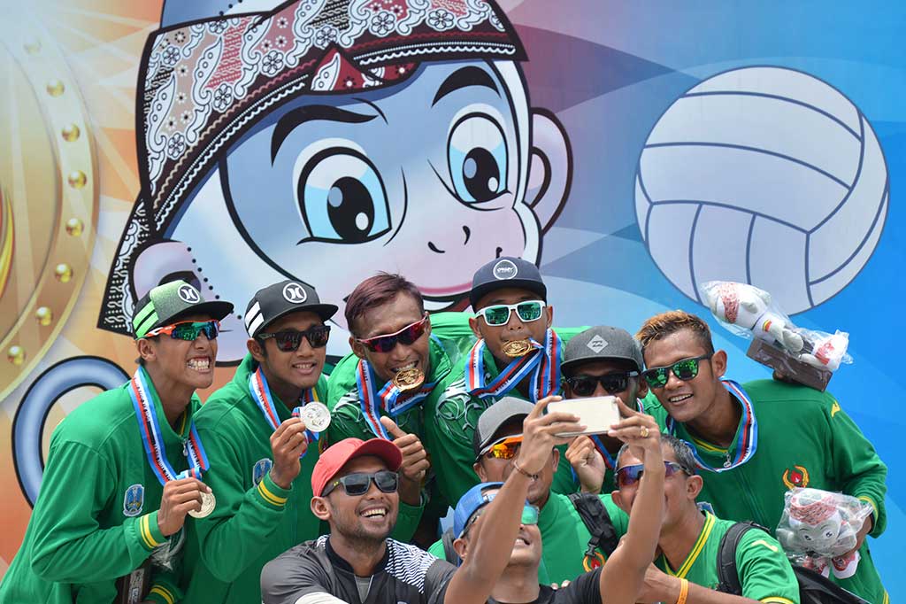 Pemain bola voli pasir DIY Ade Chandra Rachmawan (ketiga kiri) dan Gilang Ramadhan (ketiga kanan) berfoto bersama pendukungnya seusai meraih emas dengan mengalahkan tim Jatim.