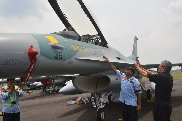 Petugas Bea Cukai memotret nomor identitas pesawat tempur F-16 sesaat setelah mendarat di Pangkalan Udara TNI AU Iswahjudi, Magetan.
