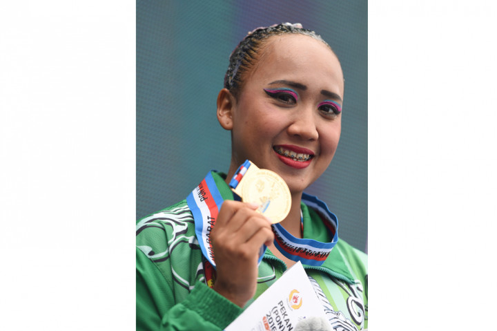 Atlet renang indah putri DI Yogyakarta Claudia Megawati Suyanto menunjukkan medali emas yang diraihnya pada final Solo Technical Routine Putri PON XIX di Gelangang Renang FPOK UPI Bandung, Jabar, Kamis (22/9/2016)