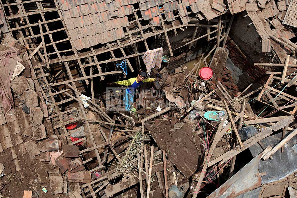 Seorang pria berada di dalam salah satu rumah yang hancur akibat diterjang banjir bandang di Desa Haurpanggung, Tarogong Kidul.
