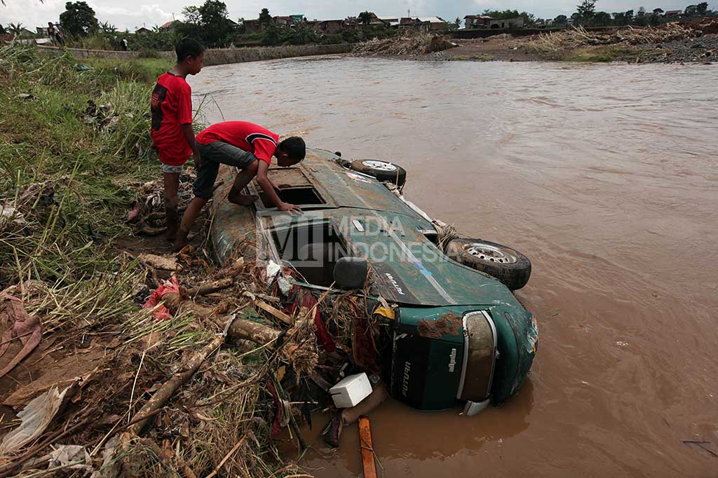Sebuah mobil terbalik dan terendam air setelah diterjang banjir bandang.