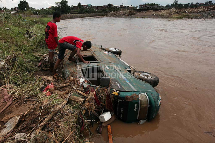 Sebuah mobil terbalik dan terendam air setelah diterjang banjir bandang.