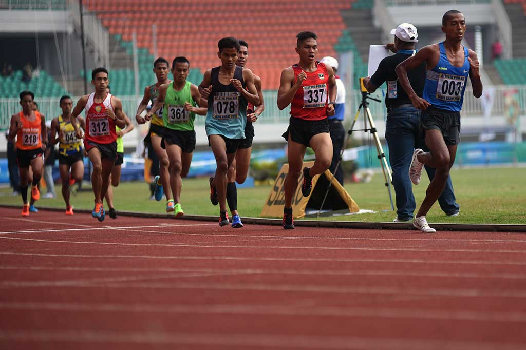 Atlet Jabar Agus Prayogo (kanan) berada di depan pelari lainnya pada nomor lomba lari 5.000 meter putra PON XIX di Stadion Pakansari, Cibinong, Bogor, Jawa Barat, Jumat (23/9/2016).
