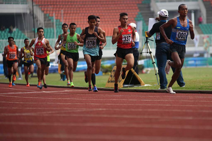 Atlet Jabar Agus Prayogo (kanan) berada di depan pelari lainnya pada nomor lomba lari 5.000 meter putra PON XIX di Stadion Pakansari, Cibinong, Bogor, Jawa Barat, Jumat (23/9/2016).