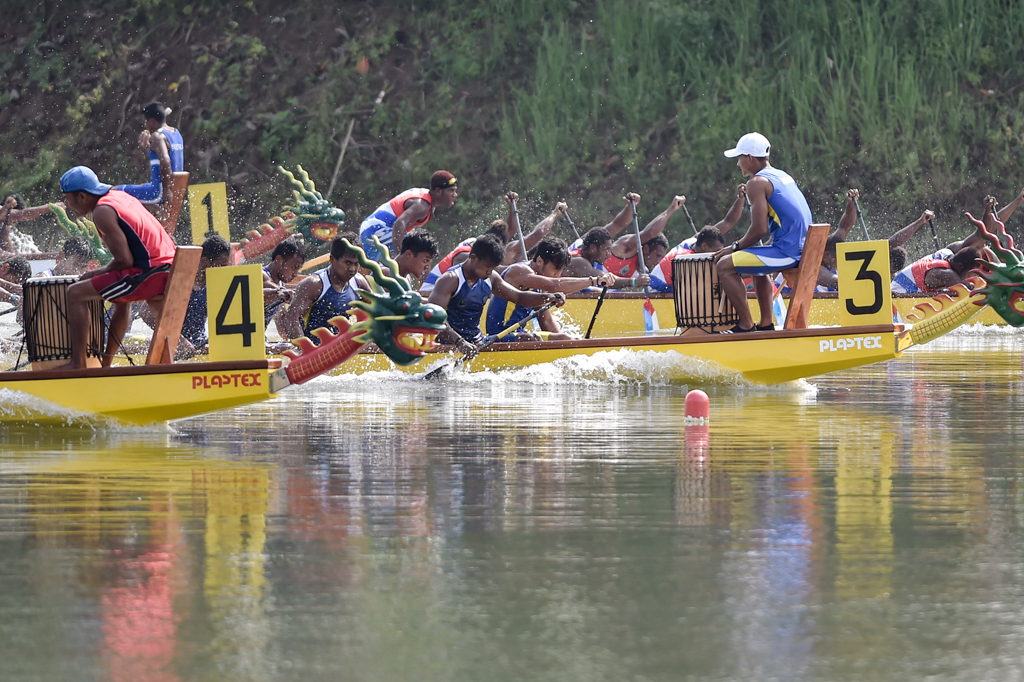 Sejumlah tim perahu naga saling beradu kecepatan pada final nomor Perahu Naga 20 Orang Putra 1000 meter PON XIX.
