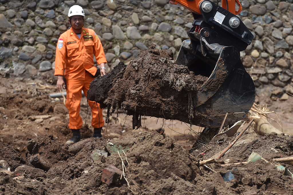 Petugas Basarnas memperhatikan upaya pencarian korban menggunakan alat berat pascabanjir bandang aliran Sungai Cimanuk di Lapang Paris, Tarogong Kidul, Kabupaten Garut, Jabar, Jumat (23/9/2016).