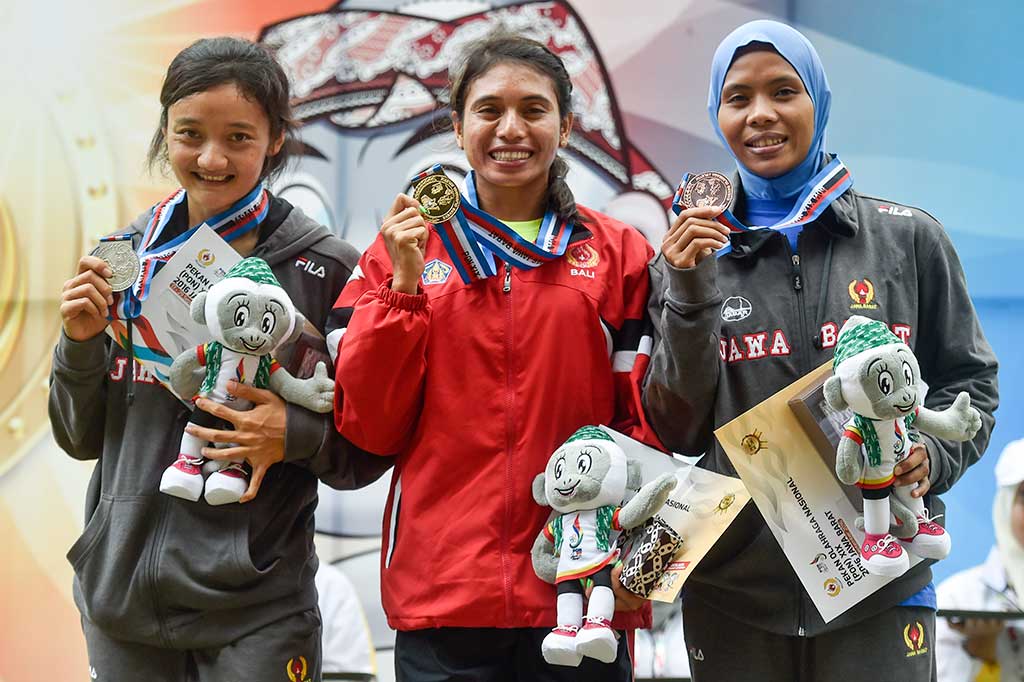 Maria Londa (tengah) bersama Ika Puspita Dewi (kiri) dan Rini Susanti menunjukkan medali yang mereka raih.