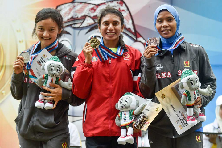 Maria Londa (tengah) bersama Ika Puspita Dewi (kiri) dan Rini Susanti menunjukkan medali yang mereka raih.