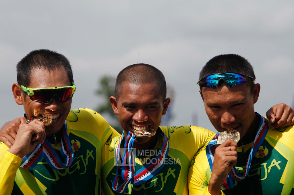 Tim balap sepeda Daerah Istimewa Yogyakarta Samai (kiri), M Nurfathoni (tengah) dan Fatahillah Abdullah menunjukkan medali emas balap sepeda track elit putra nomor tim sprint.