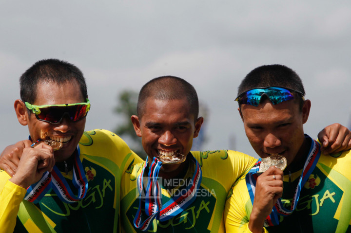 Tim balap sepeda Daerah Istimewa Yogyakarta Samai (kiri), M Nurfathoni (tengah) dan Fatahillah Abdullah menunjukkan medali emas balap sepeda track elit putra nomor tim sprint.