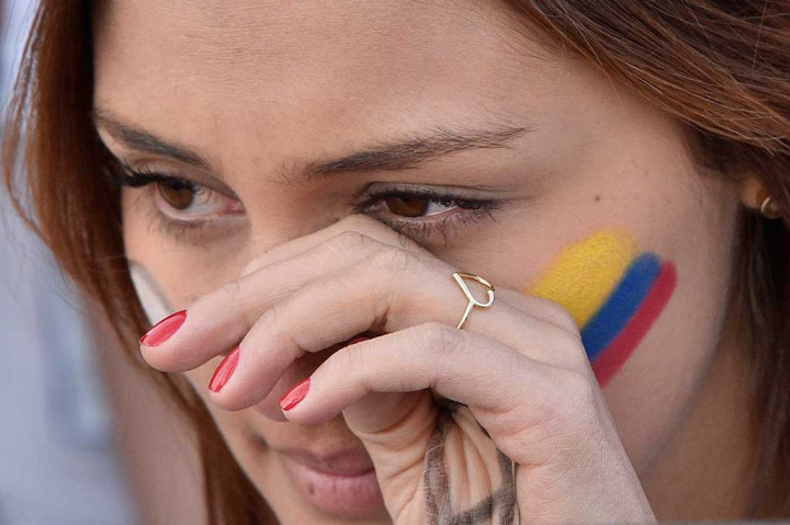 Seorang warga Kolombia tak kuasa menahan tangisnya.