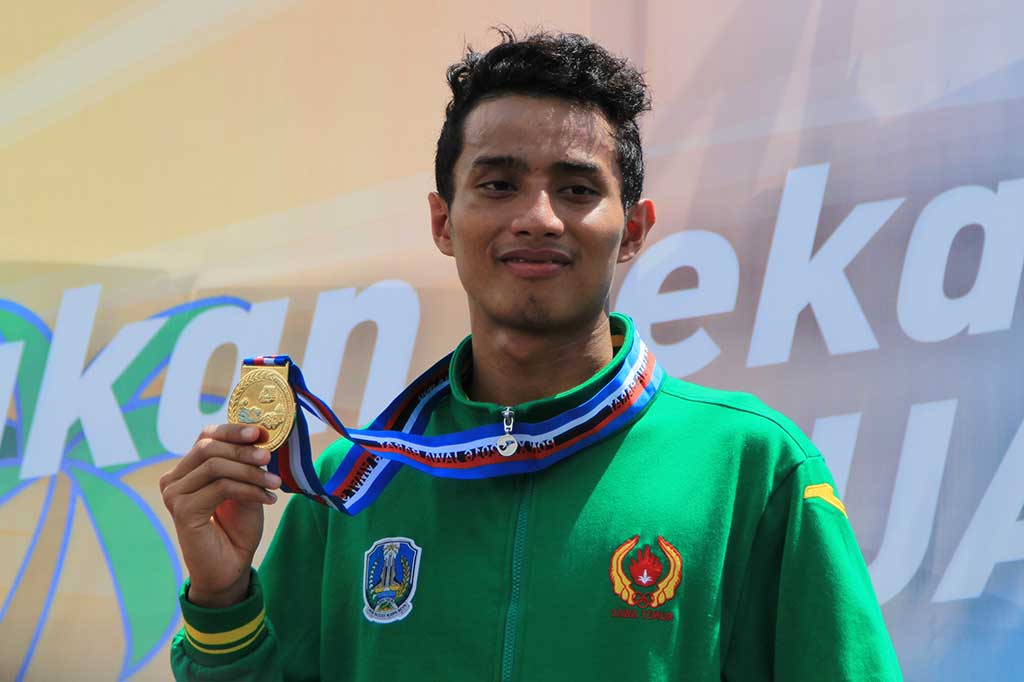 Muhammad Hamgari menunjukkan medali emas usai memenangi nomor 3.000 meter putra pada Renang Perairan Terbuka.