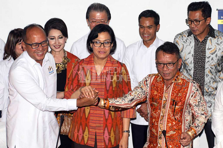 Menkeu Sri Mulyani berjabat tangan bersama Dirjen Pajak Ken Dwijugiasteadi dan Ketua Kadin Rosan P. Roeslani.