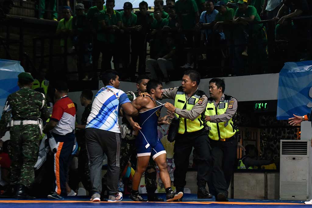 Pegulat Agus Setia (tengah) diamankan petugas usai bertanding melawan M Ivanto.