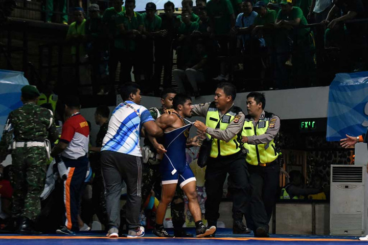Pegulat Agus Setia (tengah) diamankan petugas usai bertanding melawan M Ivanto.
