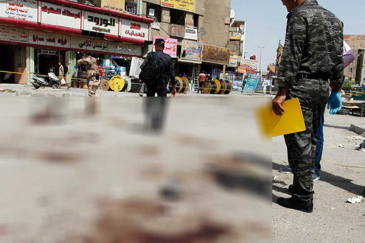 Pasukan keamanan Irak melakukan penyelidikan di lokasi serangan bom bunuh diri di sebuah pasar di Jadida. 