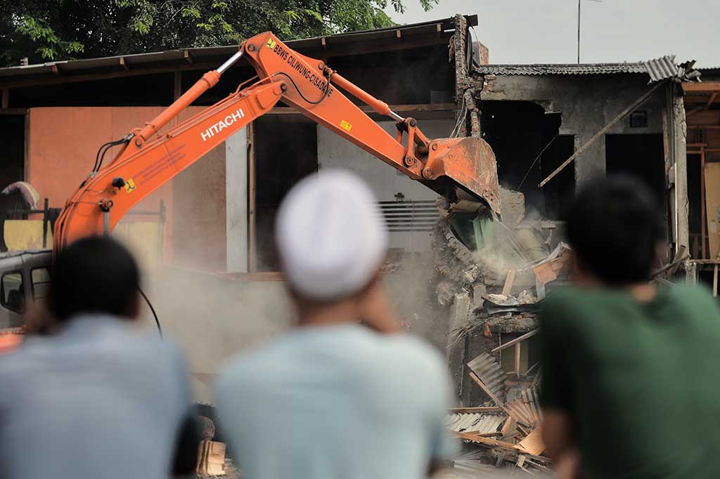 Warga melihat proses penggusuran rumah-rumah di Bukit Duri.