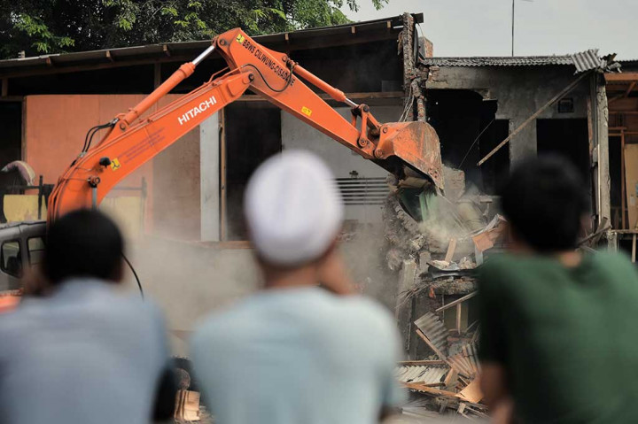 Warga melihat proses penggusuran rumah-rumah di Bukit Duri.