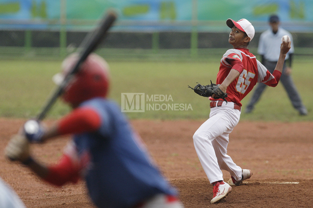 Pelempar tim bisbol DKI Jakarta melemparkan bola ke arah pemukul tim bisbol Lampung