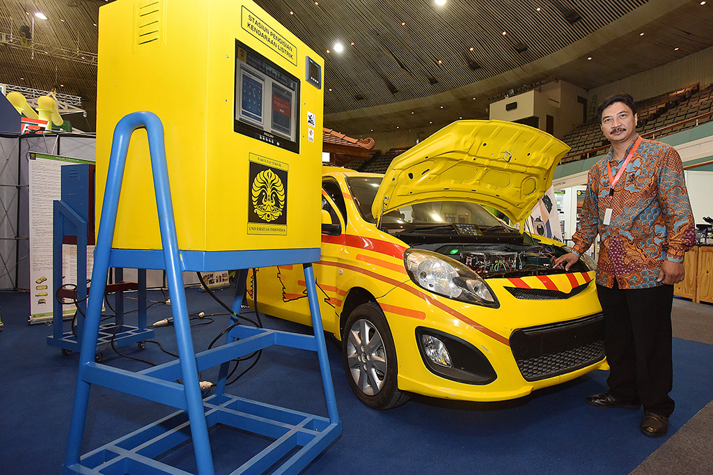 Kepala Laboratorium Teknik Kendali Fakultas Teknik Universitas Indonesia (UI) Feri Yusivar berpose di depan mobil listrik hasil inovasi dan karya dari dosen dan mahasiswa UI yang dipamerkan pada acara Seminar dan Pameran Ketenagalistrikan