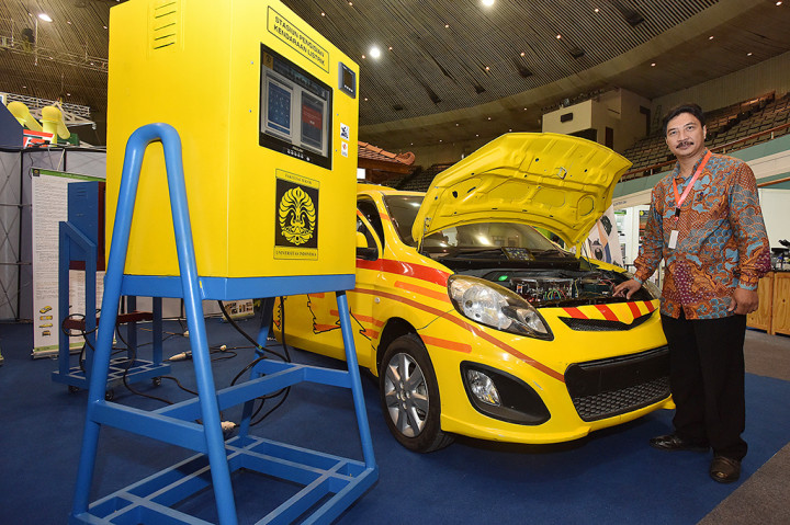 Kepala Laboratorium Teknik Kendali Fakultas Teknik Universitas Indonesia (UI) Feri Yusivar berpose di depan mobil listrik hasil inovasi dan karya dari dosen dan mahasiswa UI yang dipamerkan pada acara Seminar dan Pameran Ketenagalistrikan