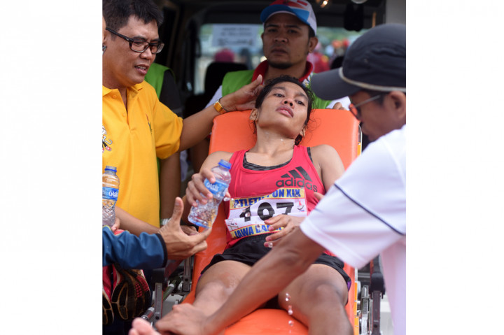 Pelari DKI Jakarta Odekta Elvina Naib (tengah) mendapatkan perawatan medis ketika lomba Lari Maraton Putri PON XIX di Cibinong, Bogor, Jawa Barat, Rabu (28/9/2016).