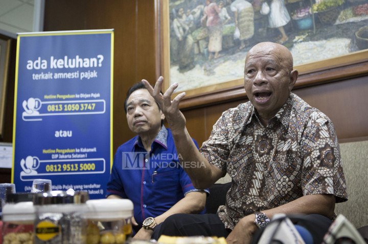 Pendiri Grup Medco Arifin Panigoro (kanan) didampingi Wakil Ketua Asosiasi Pengusaha Indonesia (APINDO) Suryadi Sasmita memberikan keterangan kepada wartawan usai mengikuti program tax amnesty.
