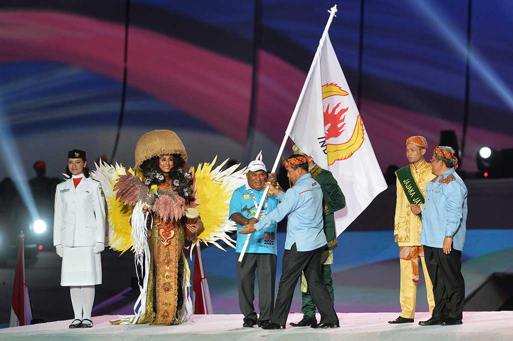 Ketua KONI Tono Suratman (kedua kanan) menyerahkan bendera PON kepada Gubernur Papua Lukas Enembe (tengah) disaksikan Gubernur Jabar Ahmad Heryawan (kanan) pada penutupan PON XIX. ANTARA/Wahyu Putro A
