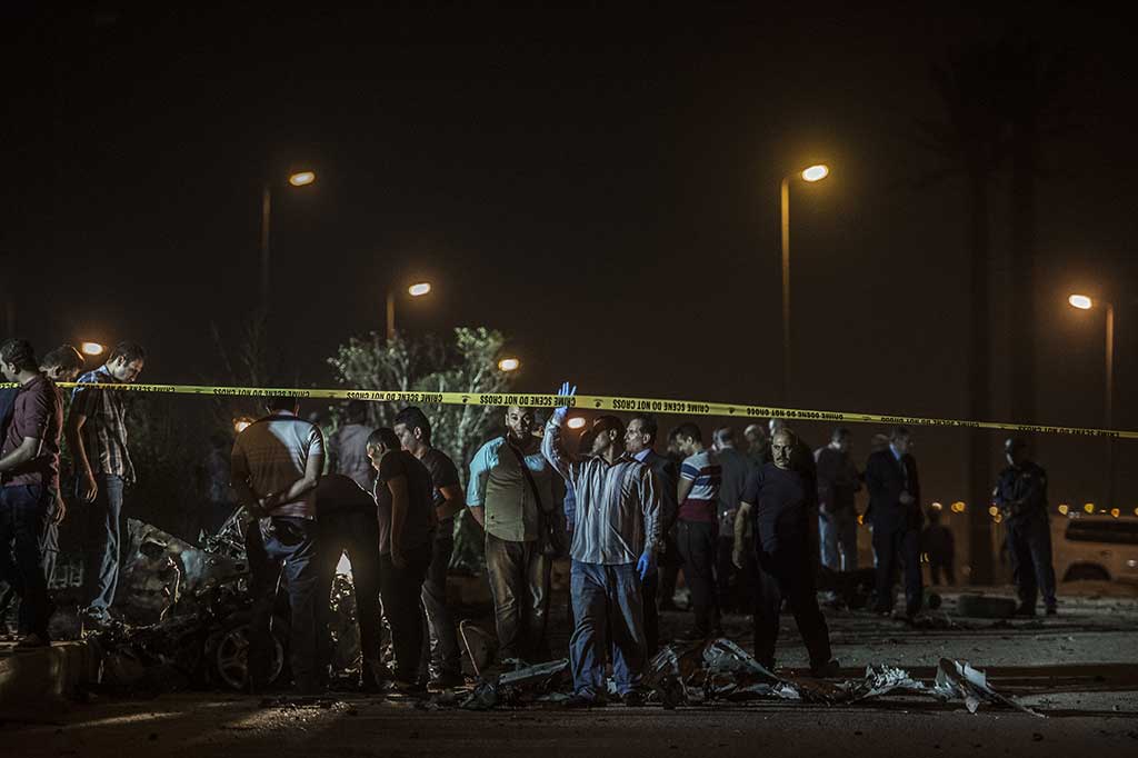 Petugas keamanan melakukan penyelidikan di tempat kejadian ledakan bom mobil di Tagammu Khamis, Kairo.