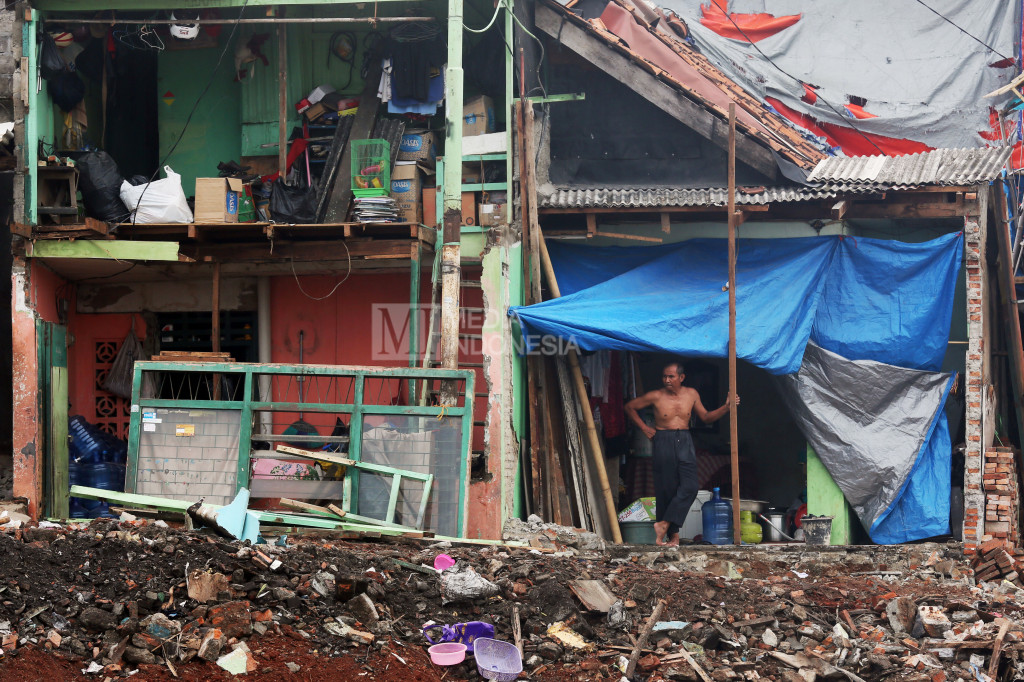 Warga berdiri di dekat bongkaran rumah mereka yang berada di RW.10 kawasan Bukit Duri, Jakarta.