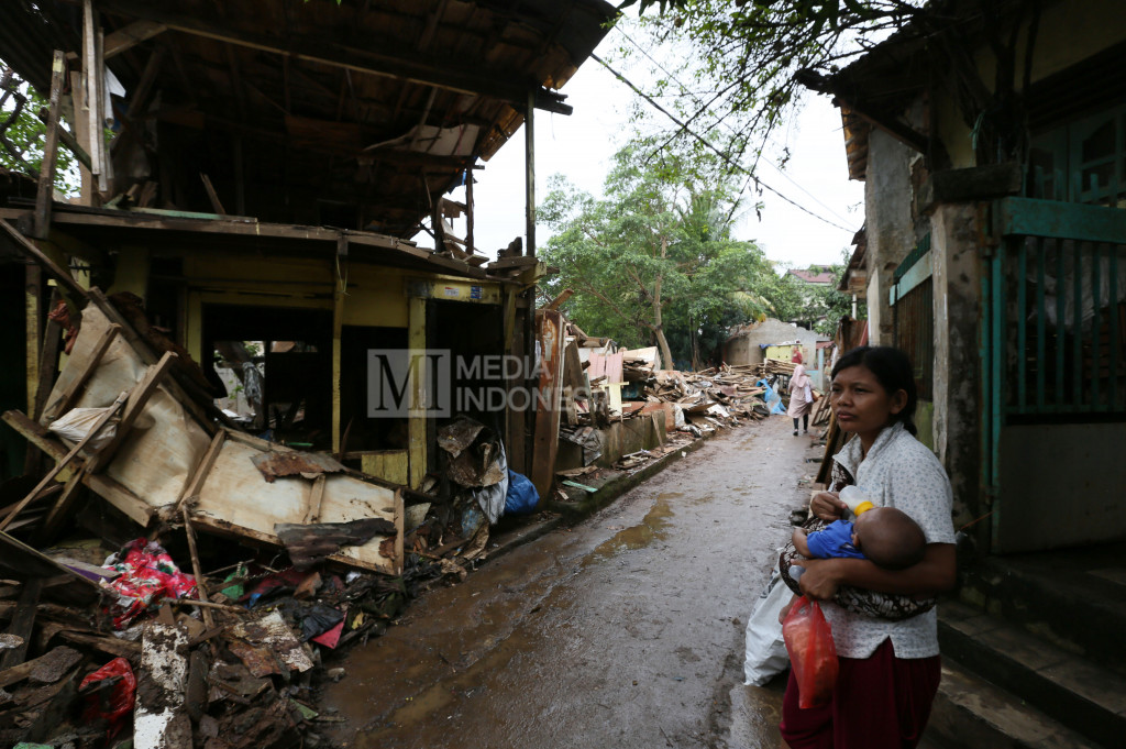 Warga berdiri di dekat bongkaran rumah mereka yang berada di RW.10 kawasan Bukit Duri, Jakarta.
