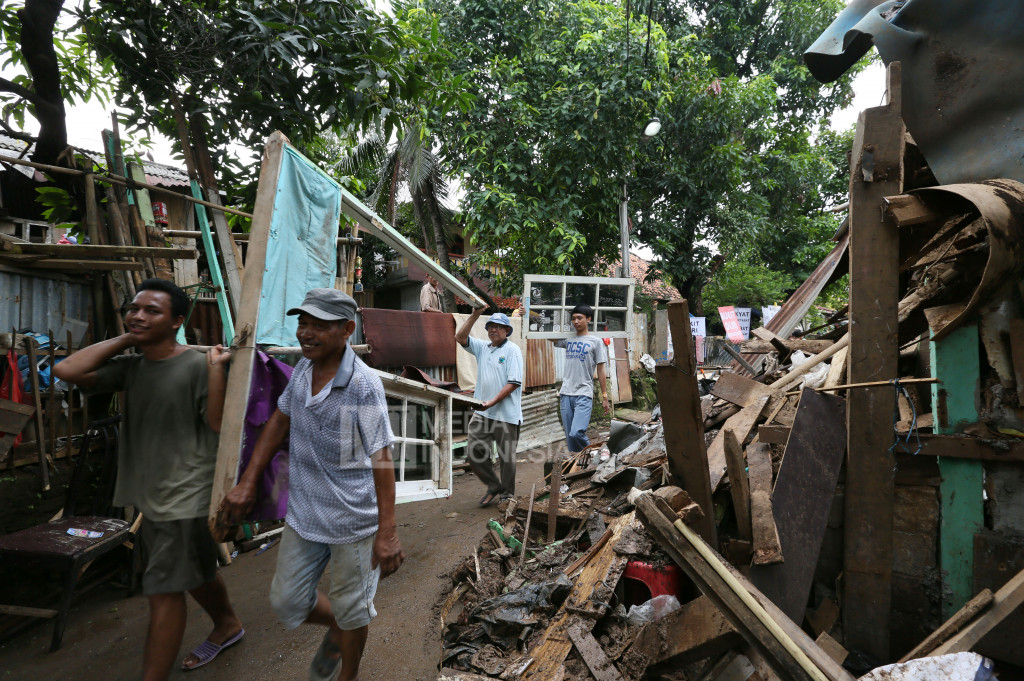 Warga membawa kusen hasil bongkaran rumah mereka yang berada di RW.10 kawasan Bukit Duri, Jakarta.