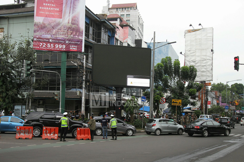 Polisi berjaga di sekitar papan billboard videotron yang menayangkan tayangan porno di Jalan Prapanca Raya, Jakarta Selatan, Jumat (30/9/2016).