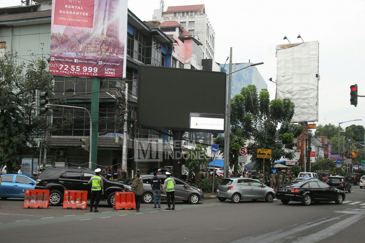 Polisi berjaga di sekitar papan billboard videotron yang menayangkan tayangan porno di Jalan Prapanca Raya, Jakarta Selatan, Jumat (30/9/2016).