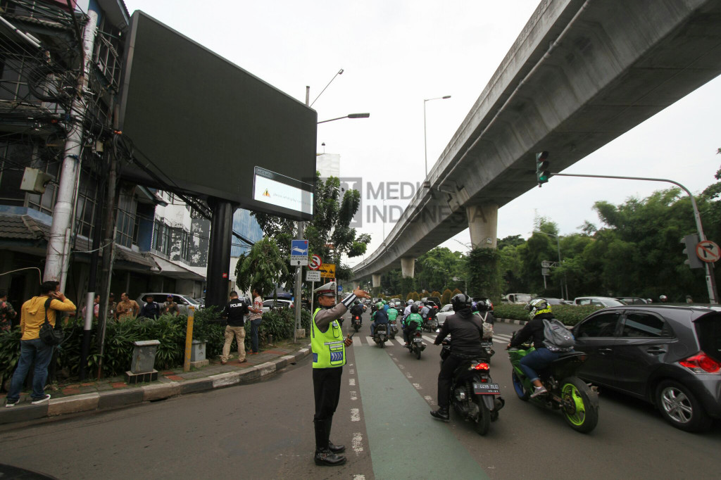 Polisi berjaga di sekitar papan billboard videotron yang menayangkan tayangan porno di Jalan Prapanca Raya, Jakarta Selatan, Jumat (30/9/2016).