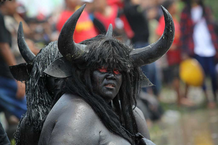 Petani mengenakan kostum kebo (kerbau) saat ritual kebo keboan Alas Malang.