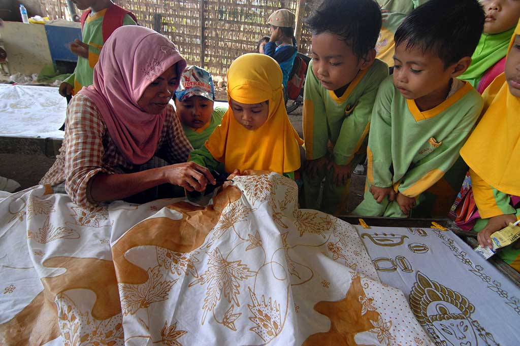 Pengrajin mengajari cara membatik kepada siswa taman kanak-kanak di Sentra Batik Pamekasan, Jatim, Sabtu (1/10/2016). Selain untuk menyambut Hari Batik Nasional, kegiatan tersebut juga untuk memperkenalkan proses pembuatan batik kepada anak-anak. ANTARA/Saiful Bahri