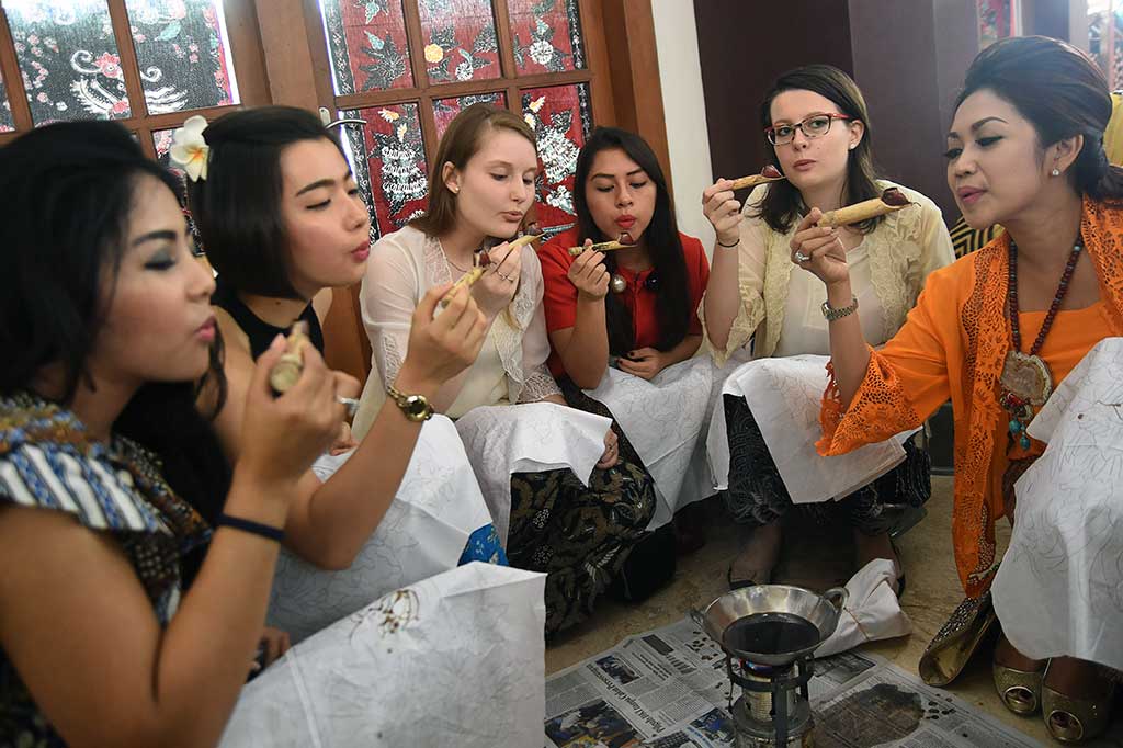 Sejumlah perempuan meniup canting bersama ketika mengikuti Jawa Timur Membatik di Komplek Balai Pemuda Surabaya, Jawa Timur, Minggu (2/10/2016). ANTARA/M Risyal Hidayat