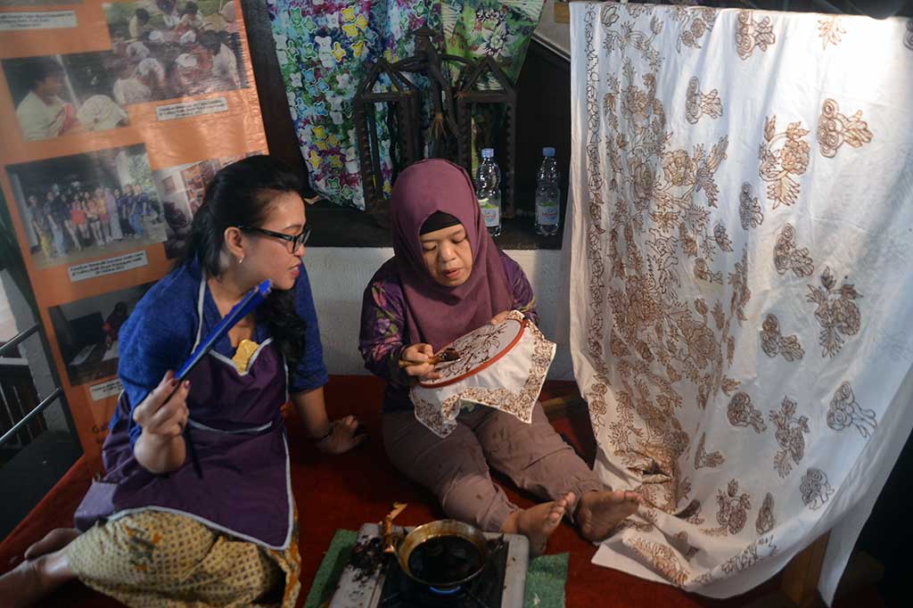Penyandang disabilitas menunjukkan cara membatik kepada pengunjung di stan pelatihan Batik Handayani Bogor, Pajajaran, Kota Bogor, Jawa Barat, Minggu (2/10/2016). ANTARA/Yulius Satria Wijaya