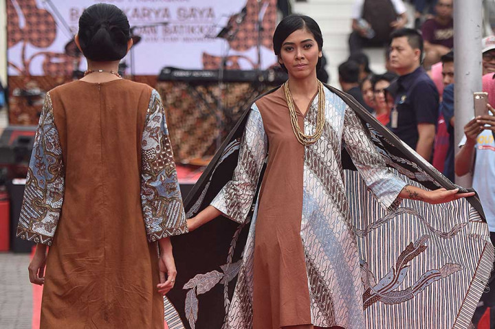 Peragawati memperagakan busana batik dalam acara Peringatan Hari Batik Nasional 2016 di pelataran parkir Gedung Sarinah, Jakarta, Minggu (2/10/2016). ANTARA/Widodo S. Jusuf